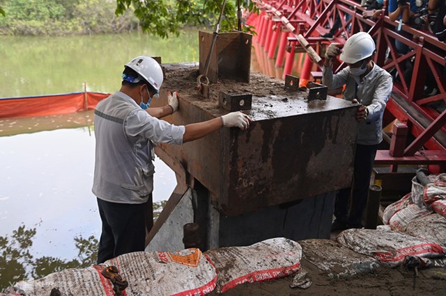 C&ocirc;ng nh&acirc;n d&ugrave;ng m&aacute;y thủy lực &eacute;p khối b&ecirc; t&ocirc;ng xuống đ&aacute;y hồ