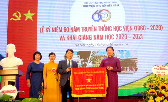 Thừa ủy quyền, đồng ch&iacute; H&agrave; Thị Nga &ndash; Chủ tịch Hội LHPN Việt Nam trao Cờ thi đua của Ch&iacute;nh phủ cho Học viện