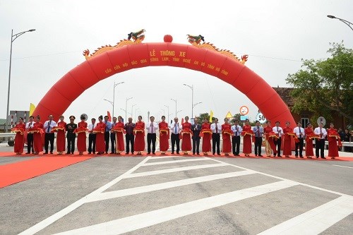 Thủ tướng Nguyễn Xu&acirc;n Ph&uacute;c c&ugrave;ng đại diện c&aacute;c bộ, ng&agrave;nh v&agrave; l&atilde;nh đạo hai tỉnh Nghệ An, H&agrave; Tĩnh cắt băng th&ocirc;ng xe cầu Cửa Hội.