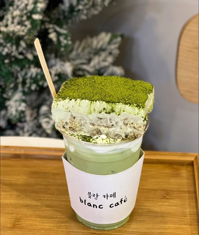 Trong khi đ&oacute;, tiramisu matcha latte l&agrave; phi&ecirc;n bản d&agrave;nh cho người y&ecirc;u tr&agrave; xanh. Matcha Nhật Bản pha c&ugrave;ng sữa tươi l&agrave;m nền, kết hợp với kem mascarpone mềm mịn tr&ecirc;n ly v&agrave; b&aacute;nh tiramisu đặt tr&ecirc;n c&ugrave;ng, tạo vị đắng nhẹ, hậu ngọt thanh v&agrave; sắc xanh tươi m&aacute;t bắt mắt