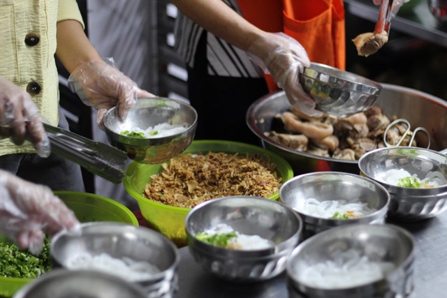 Nh&acirc;n vi&ecirc;n sử dụng bao tay v&agrave; kẹp gắp trong qu&aacute; tr&igrave;nh phục vụ.