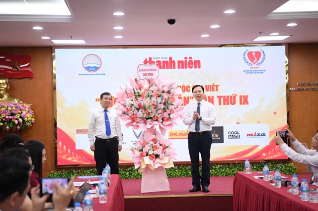 PGS.TS Lưu Văn Quảng, Ph&oacute; gi&aacute;m đốc Học viện B&aacute;o ch&iacute; v&agrave; Tuy&ecirc;n truyền trao lẵng hoa ch&uacute;c mừng cuộc thi viết "Vượt l&ecirc;n số phận" lần thứ IX