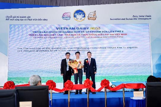 &Ocirc;ng Phạm Tuy&ecirc;n &ndash; Gi&aacute;m đốc chi nh&aacute;nh Vinamilk H&agrave; Nội (&aacute;o trắng) &ndash; nhận hoa v&agrave; kỷ niệm chương của Ban tổ chức (Ảnh: Duy Cường). &nbsp;