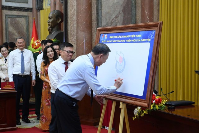 Đồng ch&iacute;&nbsp;Tổng B&iacute; thư, Chủ tịch nước T&ocirc; L&acirc;m c&ugrave;ng 101 nh&agrave; b&aacute;o ti&ecirc;u biểu thực hiện Nghi thức k&yacute; t&ecirc;n lưu niệm tr&ecirc;n tấm bảng biểu trưng kỷ niệm 101 năm Ng&agrave;y B&aacute;o ch&iacute; C&aacute;ch mạng Việt Nam.&nbsp;Ảnh: Hiền H&ograve;a &nbsp;