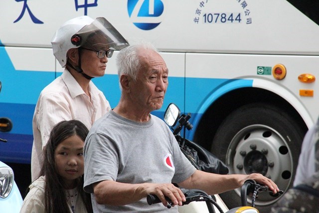 &Ocirc;ng Wang Ming &ndash; cư d&acirc;n th&agrave;nh phố H&agrave;ng Ch&acirc;u dừng xe tại ng&atilde; tư, chờ t&iacute;n hiệu đ&egrave;n giao th&ocirc;ng (Ảnh Quốc Kh&aacute;nh)