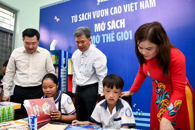 C&aacute;c em học sinh kh&aacute;m ph&aacute; tủ s&aacute;ch mới do Vinamilk trao tặng tại thư viện trường.