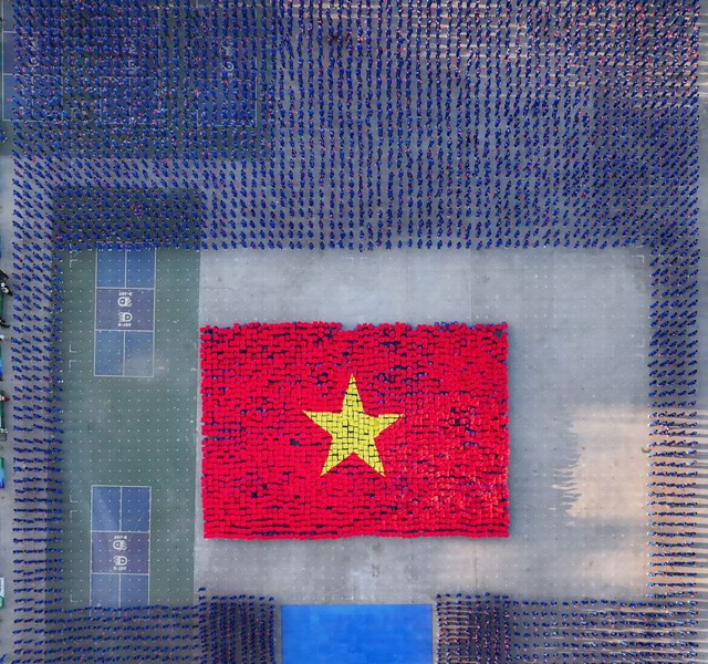 M&agrave;n xếp th&agrave;nh h&igrave;nh Quốc kỳ Việt Nam tr&ecirc;n nền nhạc Giai Điệu Tự H&agrave;o.