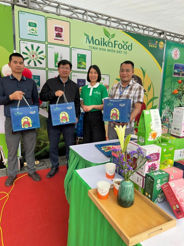 Chị Nguyễn Thị Hương - Gi&aacute;m đốc C&ocirc;ng ty TNHH Maika Food c&ugrave;ng c&aacute;c du kh&aacute;ch tham quan gian h&agrave;ng quảng b&aacute; giới thiệu về c&aacute;c sản phẩm tr&agrave; OCOP của C&ocirc;ng ty tại&nbsp;Tuần Văn h&oacute;a - Du lịch Đất Tổ năm Ất Tỵ 2025.