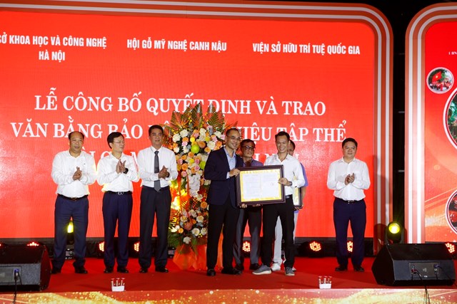 Nghi thức trao văn bằng bảo hộ nh&atilde;n hiệu tập thể Hội gỗ mỹ nghệ Canh Nậu. Ảnh: Phi Long.