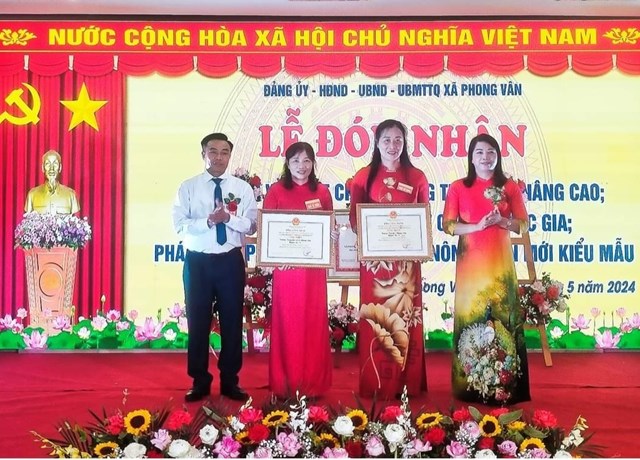 Ông Trần Quang Khuyên, PCT-UBND huyện Ba Vì và bà Ngô Thị Bích Thảo TBTC huyện ủy trao Bằng công nhận trường chuẩn Quốc gia mức độ 2 cho Trường THCS và trường Tiểu học xã Phong Vân.