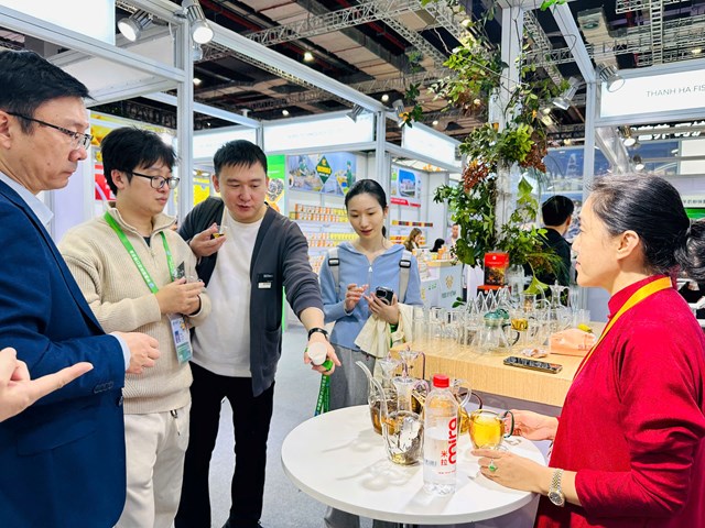 Bà Phạm Thị Thanh Hương niềm nở giới thiệu với khách tham quan gian hàng tại CIIE 2025