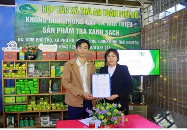 Ông Hoàng Văn Tuấn - Chủ tịch HĐQT, Giám đốc HTX trà an toàn Phú Đô và bà Dương Hồng Lệ, đại diện HTX dược liệu Phú Thiện, trao thỏa thuận ký kết hợp tác giữa hai đơn vị.