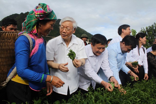 Tổng b&iacute; thư Nguyễn Ph&uacute; Trọng trao đổi với b&agrave; con d&acirc;n tộc nơi đ&acirc;y v&agrave; tham gia h&aacute;i ch&egrave; c&ugrave;ng b&agrave; con x&atilde; Bản Bo.