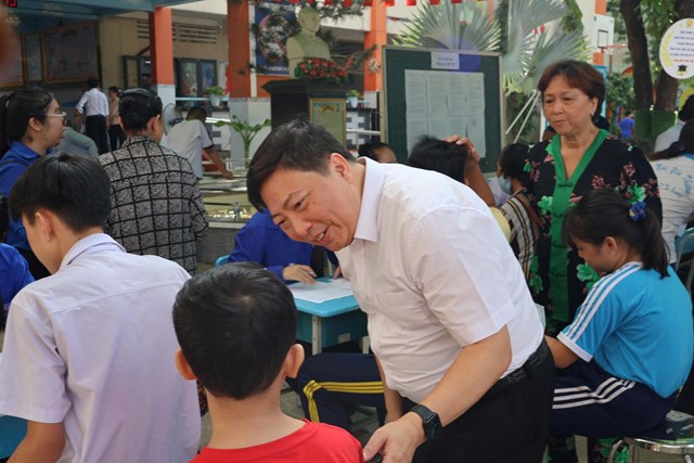 PGS.TS.BSCKII Nguyễn Vũ Trung thăm hỏi, động vi&ecirc;n người d&acirc;n tham gia chương tr&igrave;nh ti&ecirc;m vắc xin c&uacute;m miễn ph&iacute; tại phường B&igrave;nh T&acirc;y.