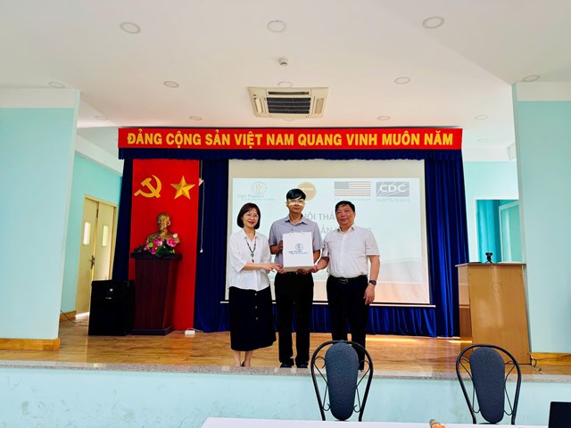Ban Tổ chức trao qu&agrave; lưu niệm cho học vi&ecirc;n Phan Minh Th&agrave;nh &ndash; TYT x&atilde; Đ&ocirc;ng Thạnh, học vi&ecirc;n thứ 100 của Chương tr&igrave;nh đ&agrave;o tạo Dịch tễ học thực địa cơ bản tại TP Hồ Ch&iacute; Minh