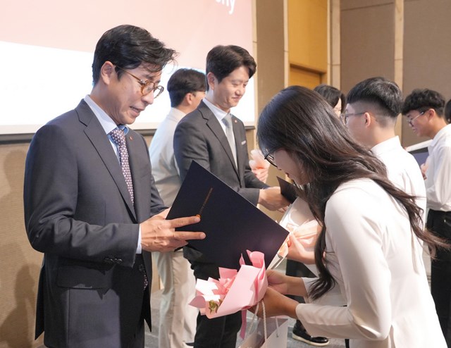 Đại diện Lotte trao chứng nhận c&ugrave;ng qu&agrave; tặng cho sinh vi&ecirc;n tại lễ trao học bổng
