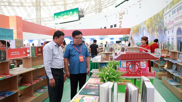 Ông Nguyễn Ngọc Bảo - Phó Cục trưởng Cục Xuất bản, In và Phát hành (áo xanh) cùng ông Ngô Văn Hoan - Phó Tổng Giám đốc NXBGDVN đến tham quan gian hàng