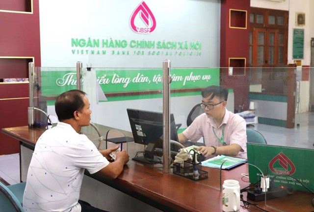 C&aacute;n bộ Ph&ograve;ng Giao dịch Ng&acirc;n h&agrave;ng Ch&iacute;nh s&aacute;ch x&atilde; hội Vĩnh Tường hướng dẫn &ocirc;ng L&atilde; Văn Mạnh, x&atilde; Vĩnh Ph&uacute;, ho&agrave;n tất thủ tục vay vốn theo chương tr&igrave;nh t&iacute;n dụng d&agrave;nh cho sinh vi&ecirc;n học ng&agrave;nh STEM.