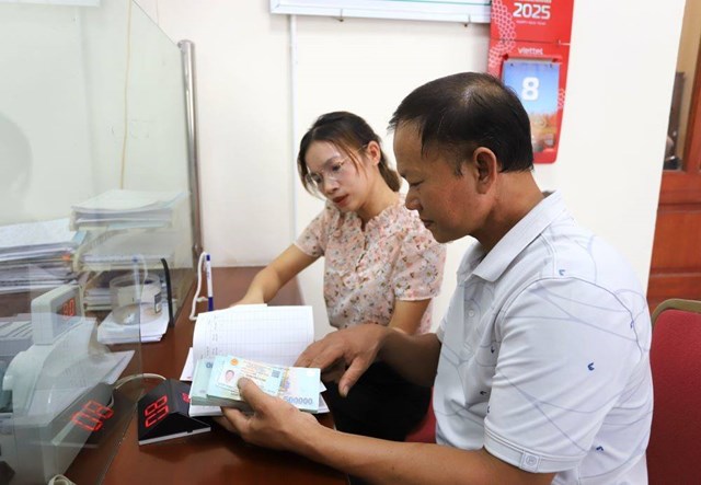 C&aacute;n bộ Ph&ograve;ng Giao dịch Ng&acirc;n h&agrave;ng Ch&iacute;nh s&aacute;ch x&atilde; hội Vĩnh Tường hướng dẫn &ocirc;ng L&atilde; Văn Mạnh, x&atilde; Vĩnh Ph&uacute;, ho&agrave;n tất thủ tục vay vốn v&agrave; nhận tiền theo chương tr&igrave;nh t&iacute;n dụng d&agrave;nh cho sinh vi&ecirc;n học ng&agrave;nh STEM.