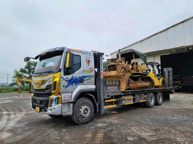 M&aacute;y ủi c&ocirc;ng tr&igrave;nh được vận chuyển bằng xe đầu k&eacute;o chuy&ecirc;n dụng, một trong những dịch vụ thế mạnh của Trai Đất Cảng.