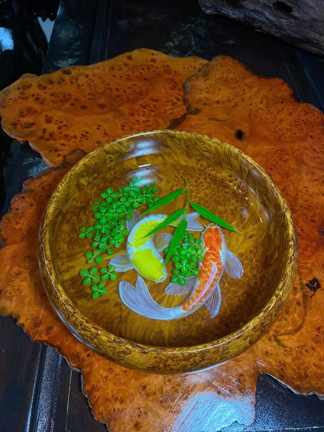 T&aacute;c phẩm mỹ nghệ gỗ với kỹ thuật vẽ v&agrave; tạo h&igrave;nh c&aacute; ch&eacute;p tinh xảo tr&ecirc;n nền gỗ qu&yacute;, thể hiện sự kết hợp h&agrave;i h&ograve;a giữa hội họa v&agrave; đi&ecirc;u khắc thủ c&ocirc;ng truyền thống.