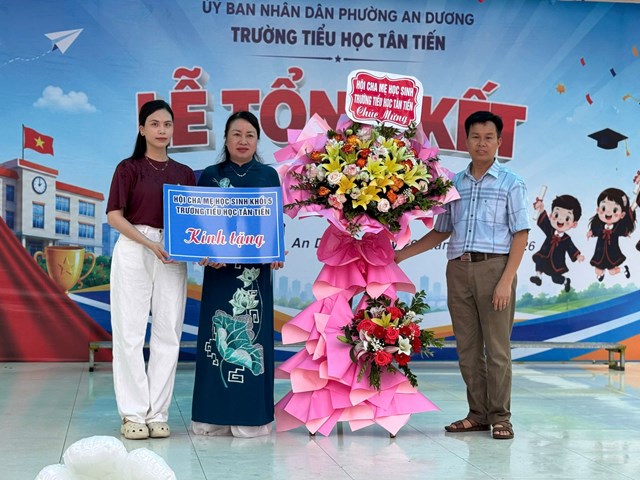 Đại diện Hội Cha mẹ học sinh Trường Tiểu học T&acirc;n Tiến trao tặng lẵng hoa ch&uacute;c mừng nh&agrave; trường tại Lễ tổng kết năm học, s&aacute;ng 29/5.