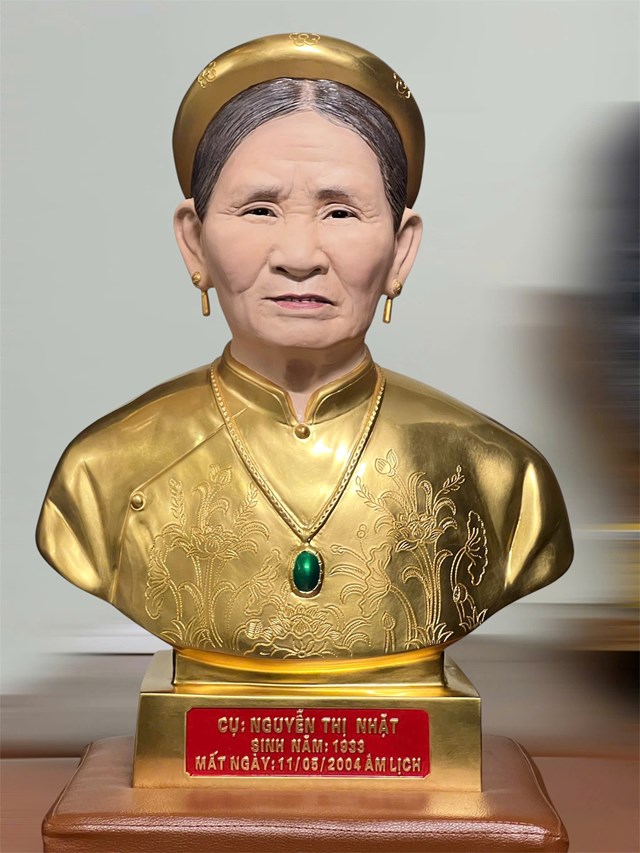 Tượng ch&acirc;n dung cụ Nguyễn Thị Nhặt bằng đồng d&aacute;t v&agrave;ng, chạm khắc hoa văn tr&ecirc;n &aacute;o d&agrave;i tinh tế, t&ocirc;n vinh phẩm hạnh người phụ nữ Việt.