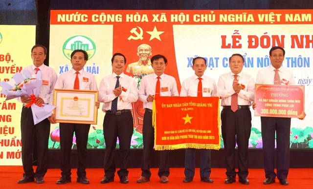 Ph&oacute; Chủ tịch Thường trực UBND tỉnh H&agrave; Sỹ Đồng trao bằng c&ocirc;ng nhận đạt chuẩn NTM, một c&ocirc;ng tr&igrave;nh ph&uacute;c lợi trị gi&aacute; 300 triệu đồng v&agrave; Cờ đơn vị dẫn đầu phong tr&agrave;o thi đua năm 2023 cho x&atilde; Gio Hải