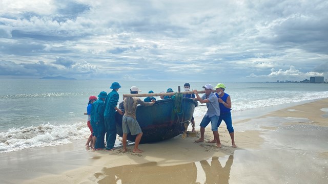 Ngư d&acirc;n khẩn vận chuyển thuyền th&uacute;ng nhỏ l&ecirc;n bờ tr&aacute;nh b&atilde;o