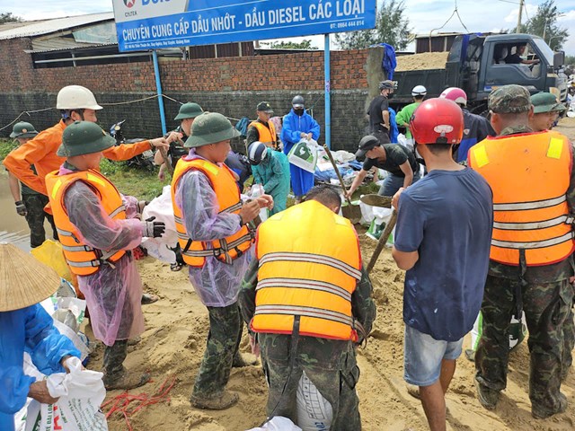 Để bảo vệ bờ kè, các lực lượng dùng cát và bao tải cát để gia cố thân kè.