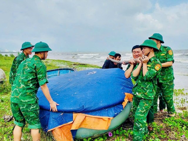 Gi&uacute;p ngư d&acirc;n đưa phương tiện l&ecirc;n bờ tr&aacute;nh b&atilde;o.