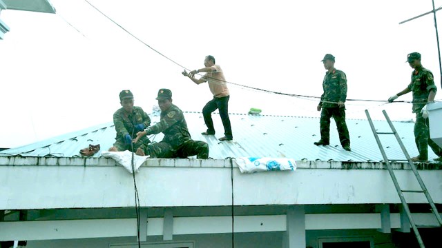 Gi&uacute;p nh&acirc;n d&acirc;n chằng chống nh&agrave; cửa trước khi b&atilde;o số 13 đổ bộ.