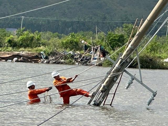 Mặc d&ugrave; nước lũ chưa r&uacute;t hẵn nhưng những trụ điện ng&atilde; đổ giữa đồng cũng đ&atilde; được c&aacute;c c&ocirc;ng nh&acirc;n điện lực kh&ocirc;i phục khẩn trương.