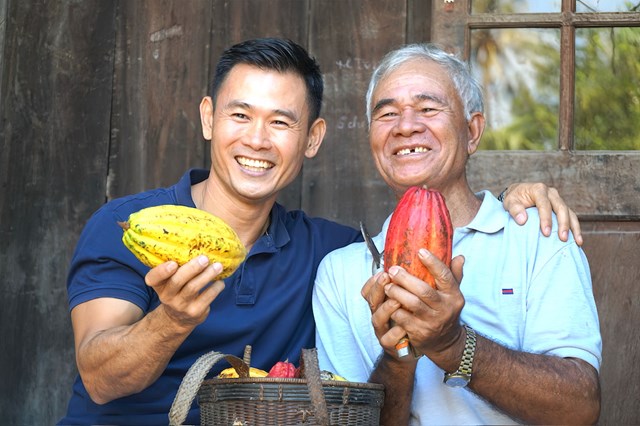 Anh Trần Quốc T&ugrave;ng (&aacute;o xanh than đen) c&ugrave;ng c&aacute;c nghệ nh&acirc;n b&ecirc;n những tr&aacute;i cacao ch&iacute;n vừa thu hoạch, kết tinh th&agrave;nh quả lao động v&agrave; t&acirc;m huyết g&igrave;n giữ nguồn gen cacao qu&yacute;.