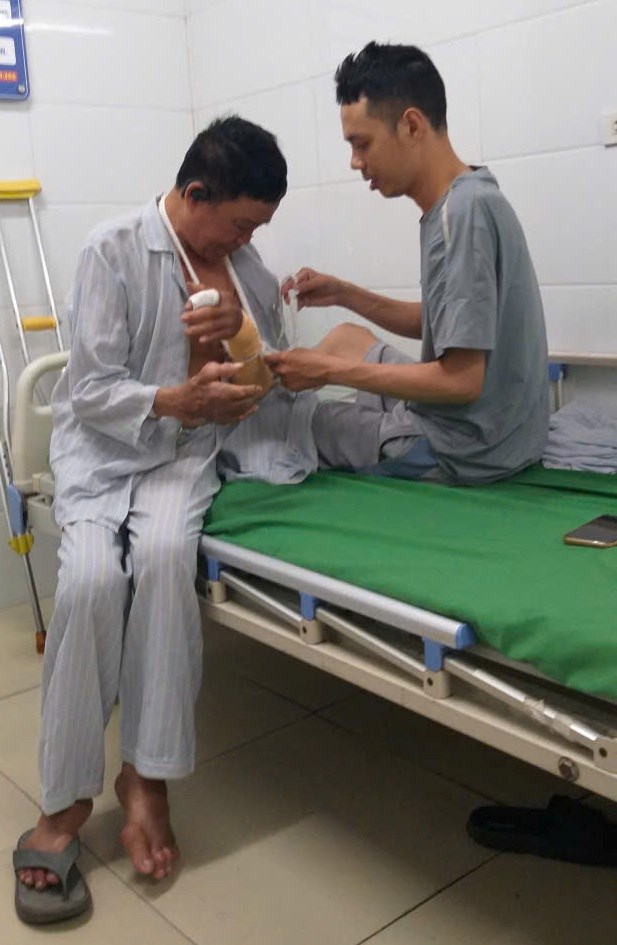 Bệnh nh&acirc;n Cường gi&uacute;p &ocirc;ng Dương Văn Lạc đến từ Y&ecirc;n Th&agrave;nh sửa lại d&acirc;y đeo v&igrave; hai c&aacute;nh tay &ocirc;ng kh&ocirc;ng thể tự vận động