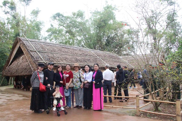 B&agrave; Li&ecirc;n (&aacute;o đỏ đứng giữa) c&ugrave;ng gia đ&igrave;nh chụp chung c&aacute;c hướng dẫn vi&ecirc;n, thuyết minh tại nh&agrave; B&aacute;c