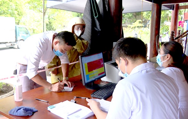Người dân thực hiện khai báo y tế tại chốt kiểm soát liên ngành phòng, chống dịch Covid-19 xã Đội Bình (Yên Sơn) - Ảnh: Minh Hoa