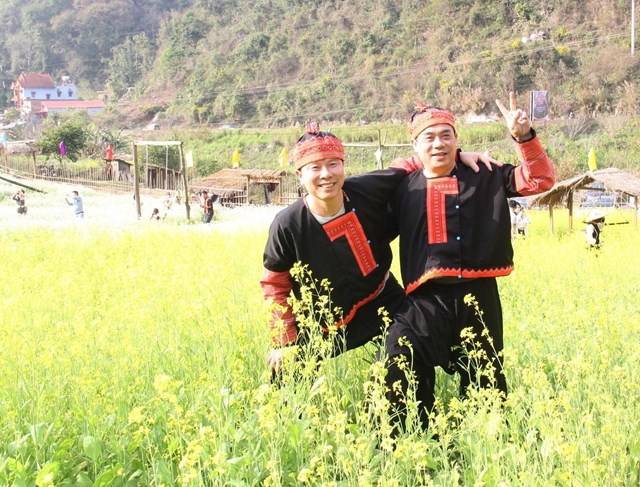 Du khách chụp ảnh với trang phục truyền thống của đồng bào dân tộc Mông. 