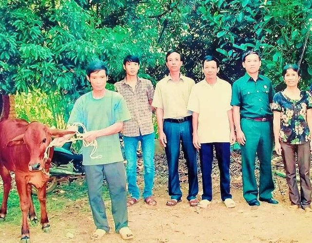 Đại diện Ủy ban MTTQ xã Tiên Phong và các ban ngành trao tặng bò cho hộ nghèo 