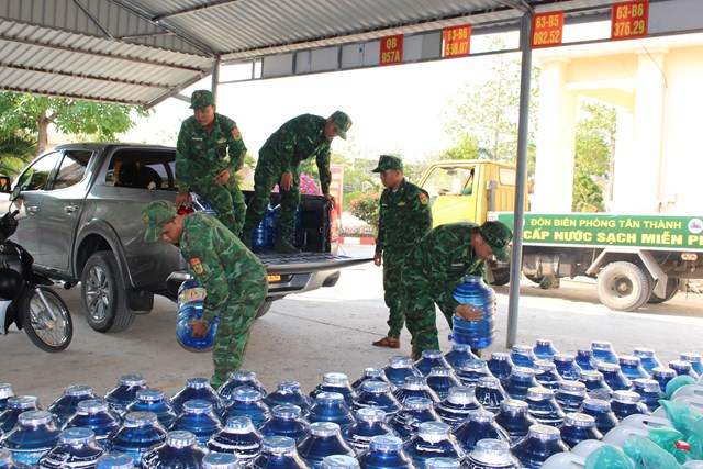 C&aacute;n bộ, chiến sĩ Đồn Bi&ecirc;n ph&ograve;ng T&acirc;n Th&agrave;nh vận chuyển từng b&igrave;nh nước uống l&ecirc;n xe &ocirc; t&ocirc; b&aacute;n tải để đưa đến c&aacute;c điểm, c&aacute;c hộ gia đ&igrave;nh cấp ph&aacute;t cho người d&acirc;n. &nbsp;