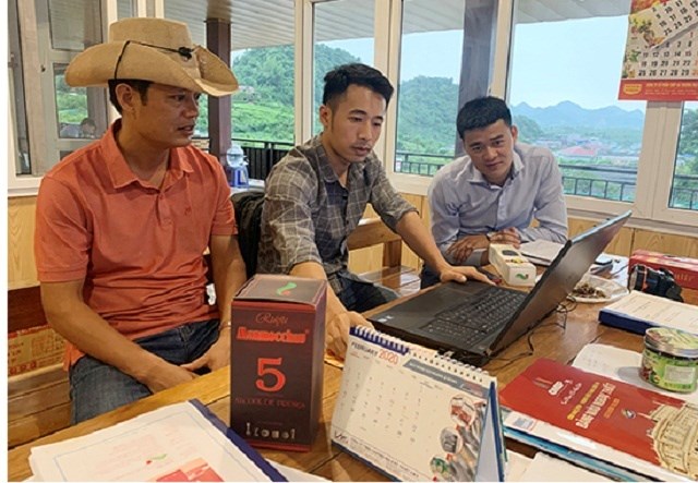 &Ocirc;ng Mai Đức Thịnh ( Người đội mũ) Gi&aacute;m đốc HTX Dịch vụ ph&aacute;t triển n&ocirc;ng nghiệp 19-5 c&ugrave;ng trao đổi thiết kế bao b&igrave; cho c&aacute;c sản phẩm.