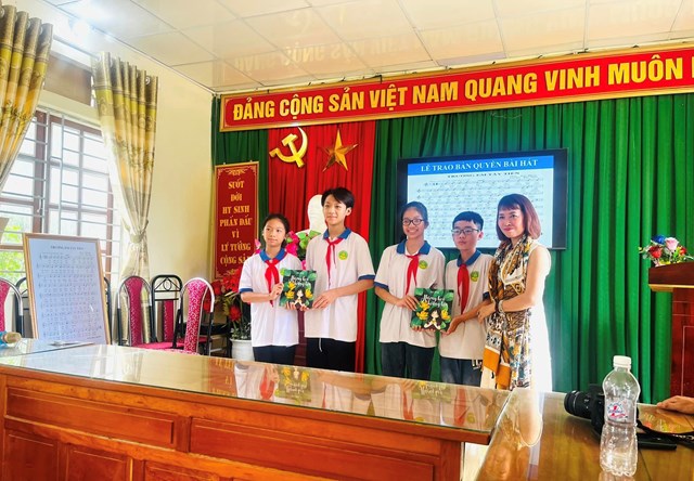 Nhà thơ Bảo Ngọc tặng tập thơ cho các em học sinh.