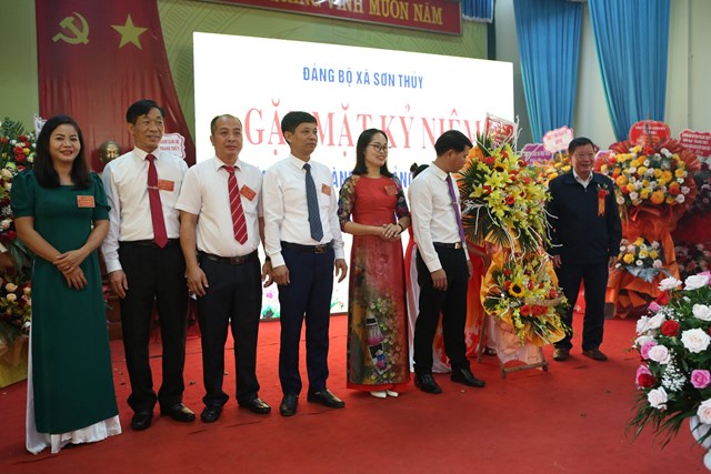 Đại diện những người con qu&ecirc; hương Sơn Thủy c&ocirc;ng t&aacute;c trong v&agrave; ngo&agrave;i tỉnh tặng hoa ch&uacute;c mừng buổi gặp mặt. Ảnh: Phi Long.