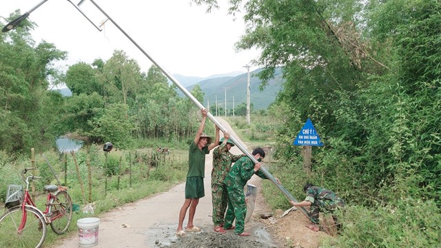 Người l&iacute;nh qu&acirc;n h&agrave;m xanh c&ugrave;ng với người d&acirc;n lắp đặt hệ thống đ&egrave;n đường chiếu s&aacute;ng.