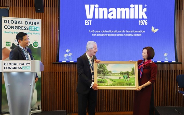 Đại diện Vinamilk trao tặng bức tranh trang trại Green Farm của Vinamilk đến chủ tịch hội nghị sữa to&agrave;n cầu - &ocirc;ng Richard Hall (b&ecirc;n tr&aacute;i) &nbsp;