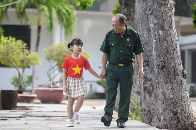 Thượng sĩ Nguyễn Ch&iacute; Tường c&ugrave;ng con một nh&acirc;n vi&ecirc;n Vinamilk tại Trung t&acirc;m Điều dưỡng Thương binh v&agrave; Người c&oacute; c&ocirc;ng Long Đất (Ảnh: Thanh B&igrave;nh). &nbsp;