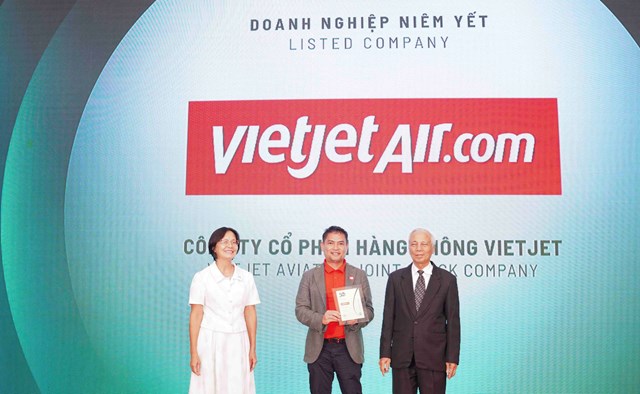 &Ocirc;ng Nguyễn An Di - Gi&aacute;m đốc Nh&acirc;n sự Vietjet (&aacute;o T - shirt đỏ, &aacute;o kho&aacute;c ghi x&aacute;m) nhận giải thưởng t&ocirc;n vinh Top 50 doanh nghiệp ph&aacute;t triển bền vững từ ban tổ chức