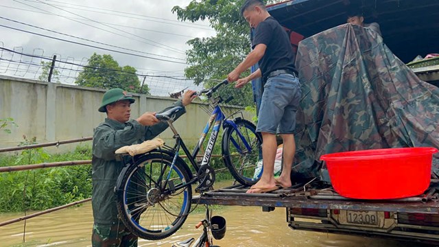 Gi&uacute;p b&agrave; con di rời t&agrave;i sản ra khỏi v&ugrave;ng ngập lụt. &nbsp;