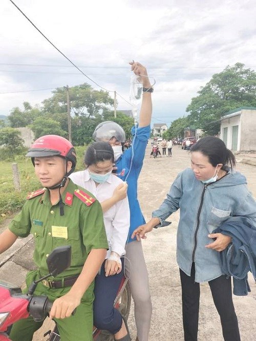 Em Nhung vừa chuyền nước đước c&aacute;c t&igrave;nh nguyện vi&ecirc;n chở đến điểm thi